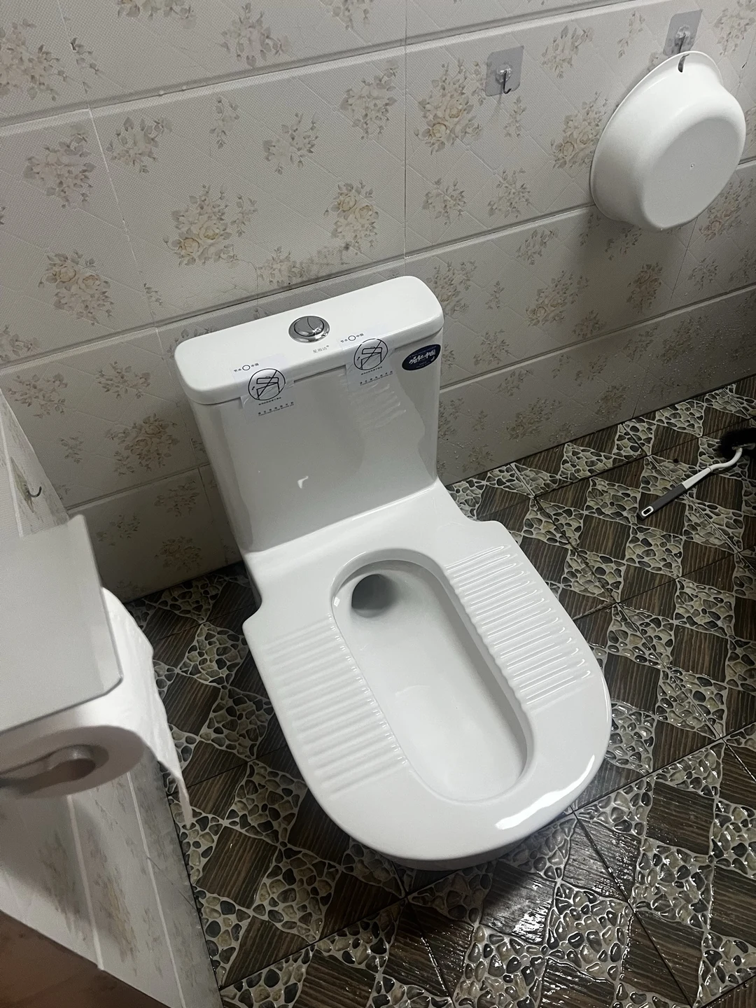 花纹墙砖和原有地面之间安装完成的台式蹲便器